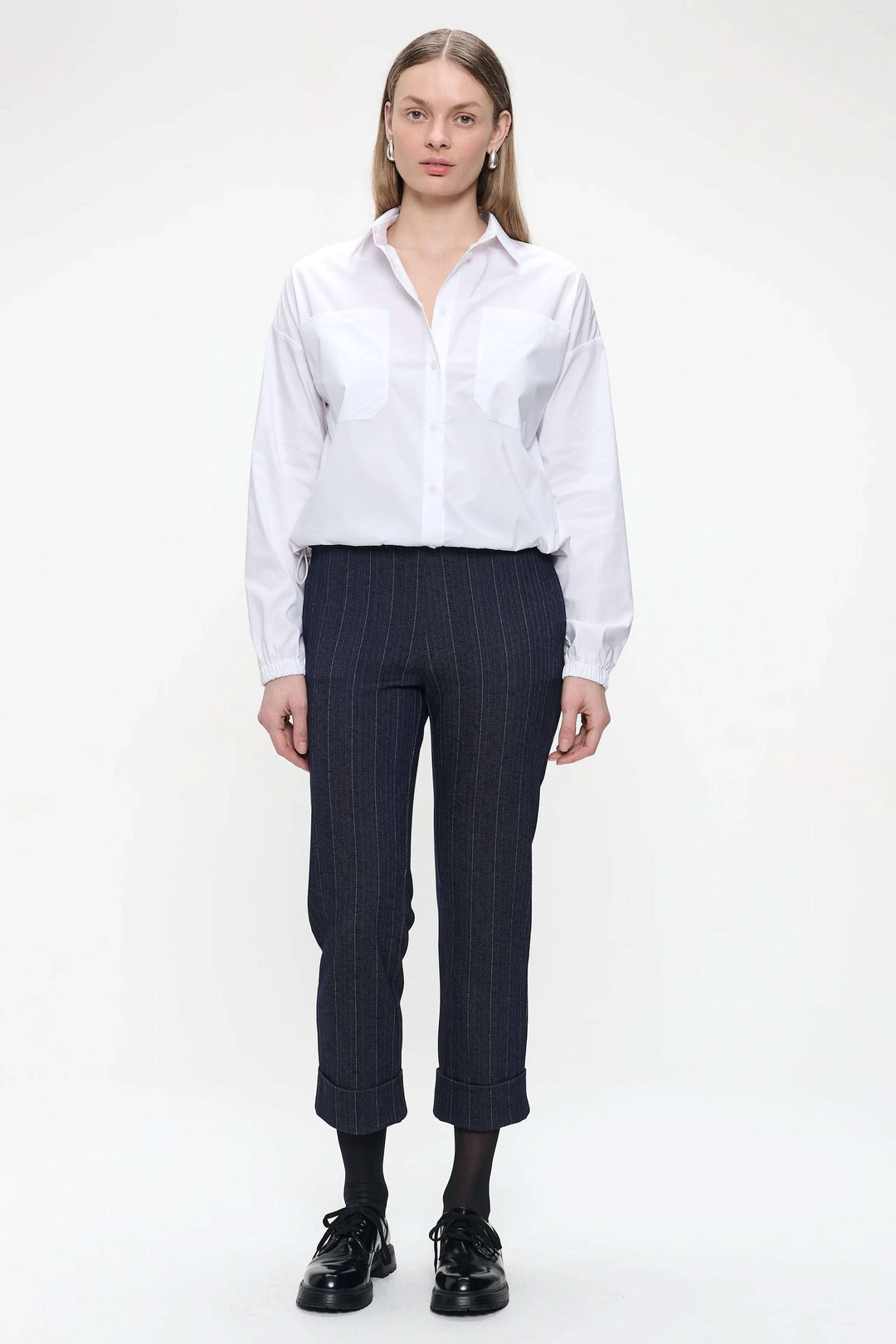 Pantalon Parrot avec motif fines rayures, longueur 7/8, classique et moderne, portée avec chemise blanche, style bureau élégant.