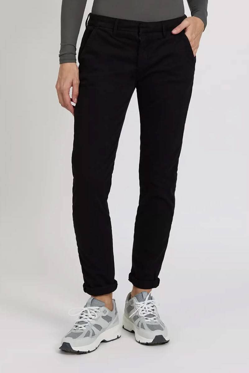 Pantalon chino Sandy noir porté avec des sneakers, mettant en avant une coupe élégante et décontractée.