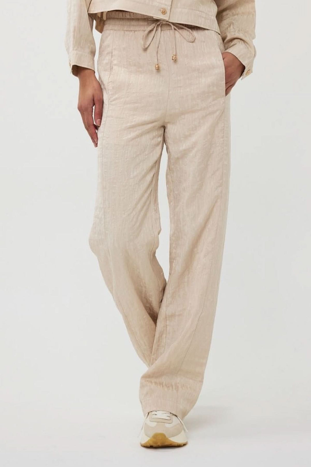 Pantalon ample en jacquard texturé beige avec taille élastique et cordon, idéal pour l&