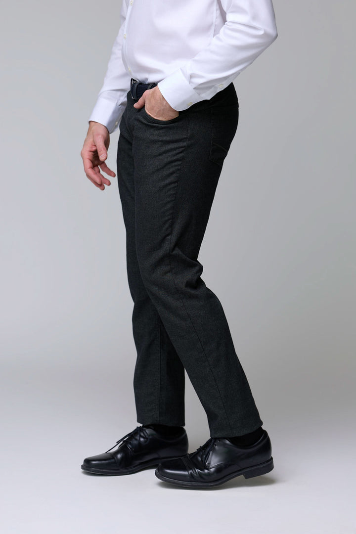 Pantalon en laine extensible noir porté par un homme avec chemise blanche et chaussures en cuir, coupe moderne et élégante.