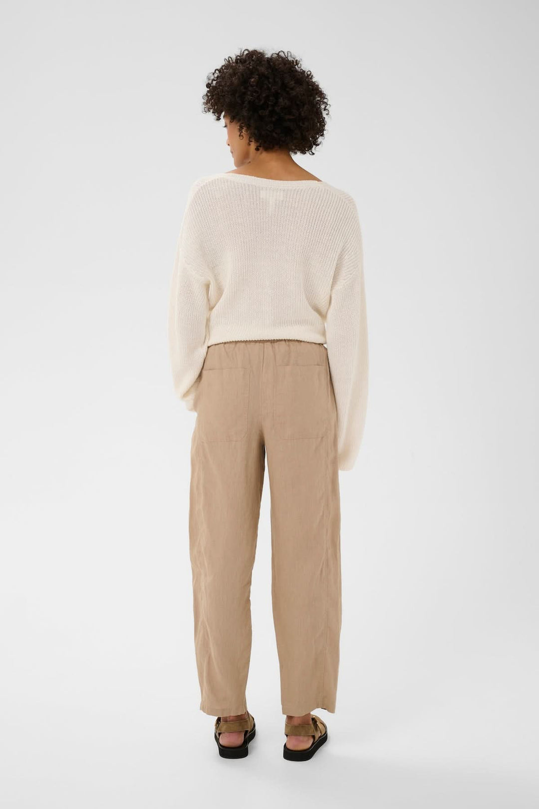 Vue arrière du pantalon en lin Atima beige, coupe droite et tombé souple, porté avec une tenue décontractée.