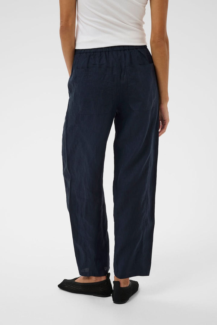 Femme portant le Pantalon en lin Atima bleu sombre, coupe droite, confort quotidien, tissu naturel.
