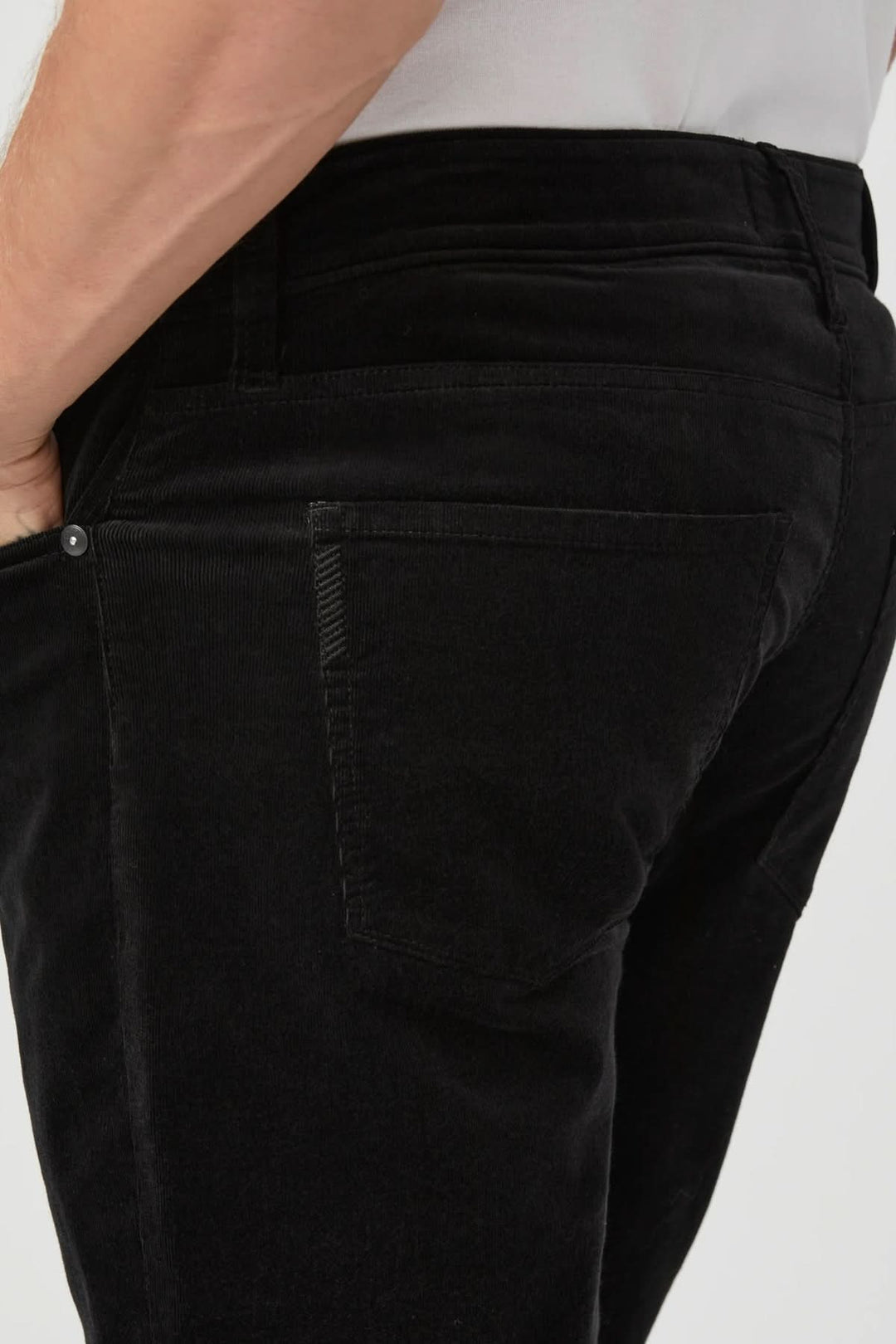 Pantalon en micro corduroy noir avec coupe ajustée montrant la poche arrière, élégance décontractée et confort supérieur.