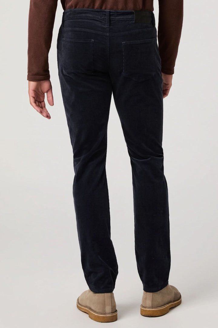 Homme portant un pantalon en micro corduroy bleu marine de dos, montrant une coupe ajustée et une finition en micro-velours côtelé.