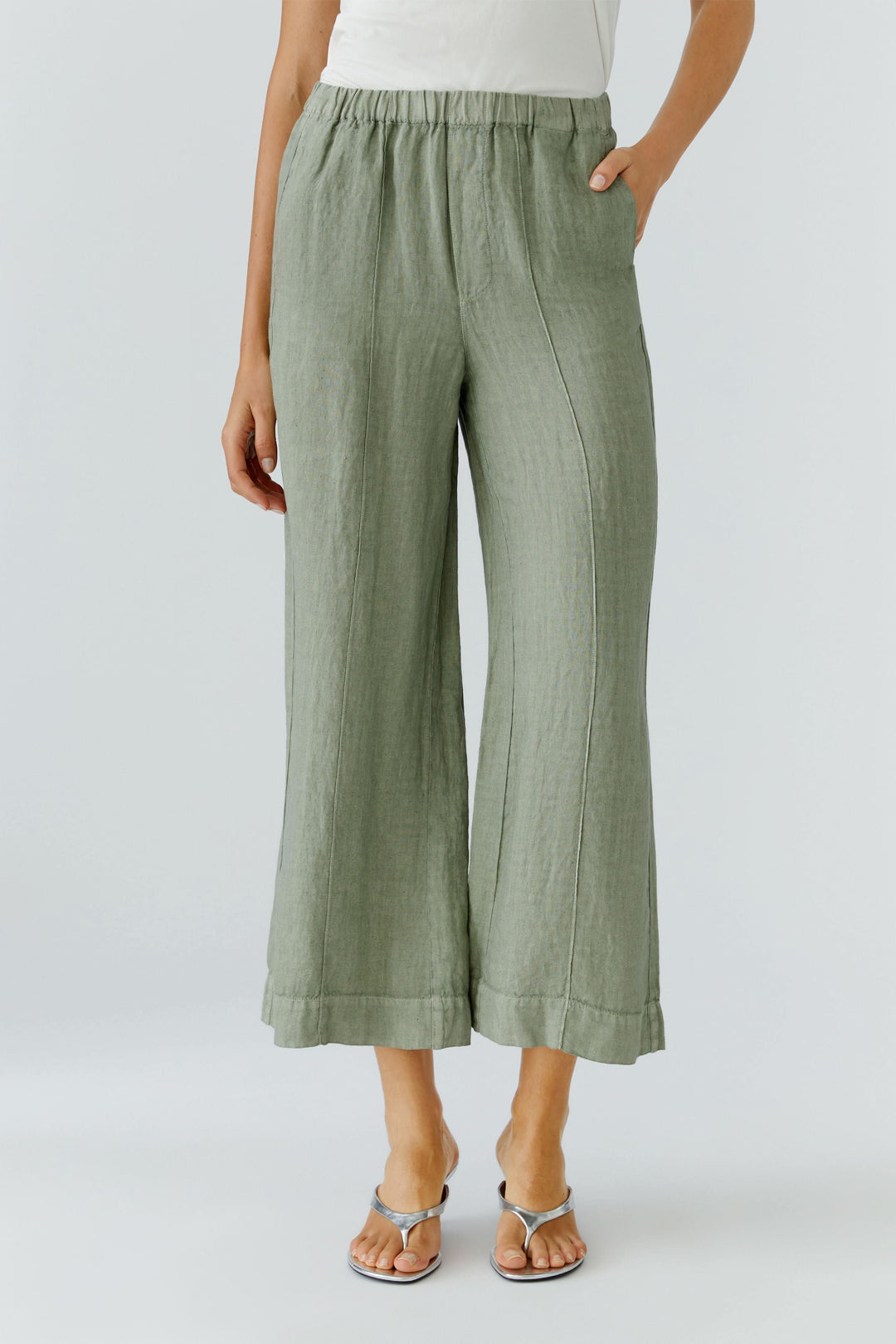 Pantalon fluide en lin à jambe large avec taille élastiquée et poches latérales pour un look moderne et décontracté.