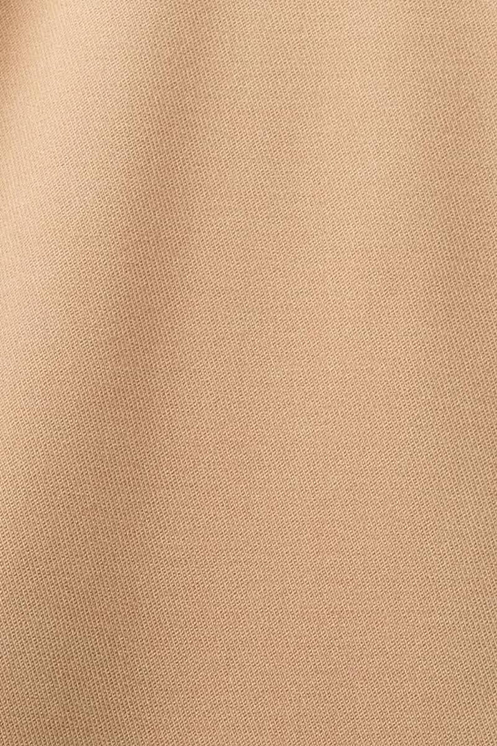 Tissu beige texturé utilisé pour les pantalons habillés, idéal pour le bureau et les événements spéciaux.