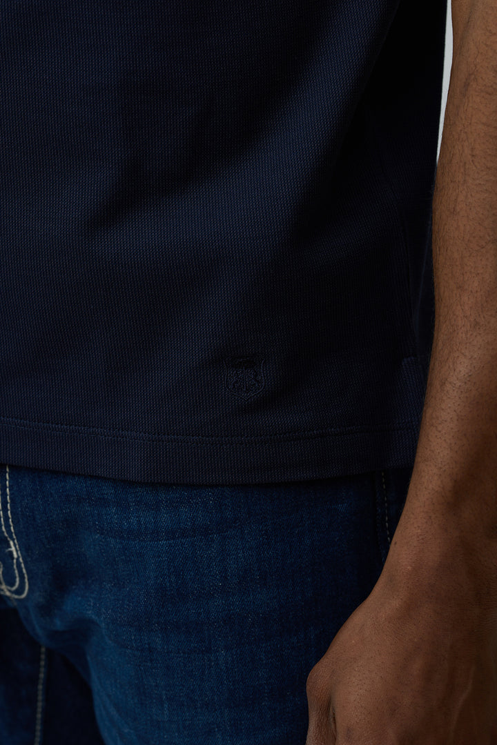 Polo en coton Corneliani bleu marine, coupe ajustée, détail de la maille fine texturée, manches courtes.