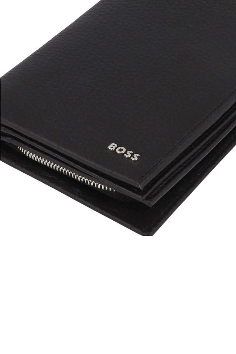 Portefeuille en cuir grainé noir avec logo métallique discret et design élégant, idéal pour cartes et billets. Accessoire moderne et fonctionnel.
