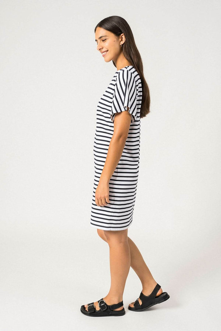 Femme portant la robe Cassis rayée, légère et chic, parfaite pour les journées ensoleillées.