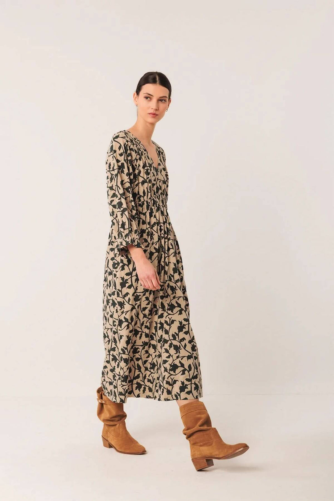 Robe longue fluide imprimé botanique avec bottes en cuir, décolleté en V et taille froncée pour un style bohème et élégant.