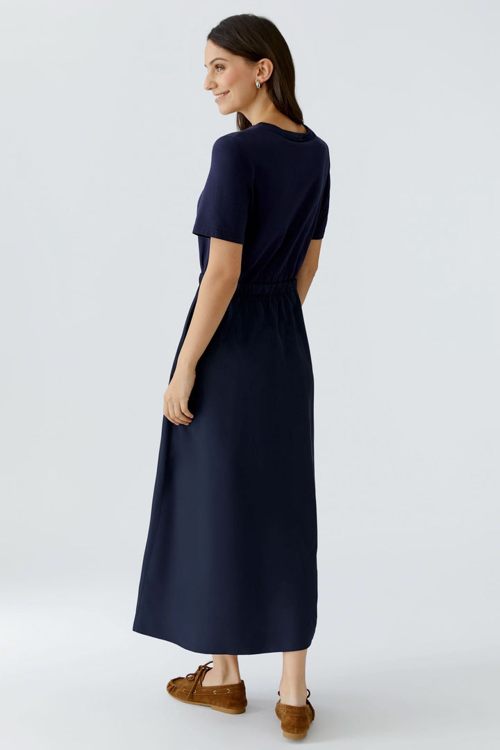 Femme portant une robe midi à taille ajustable, vue de dos, mettant en valeur l&