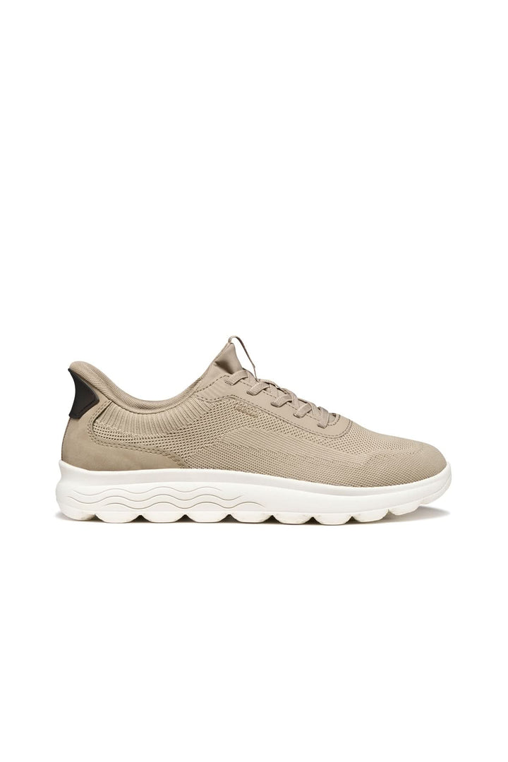 Sneaker en maille respirante beige avec semelle amortissante, vue latérale.