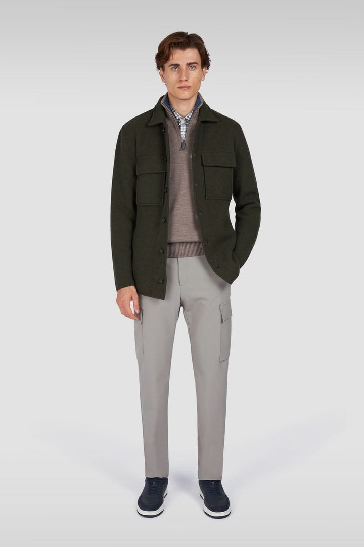 Homme portant une surchemise en laine texturée avec poches plaquées, assortie à un pantalon gris pour un style moderne et élégant.