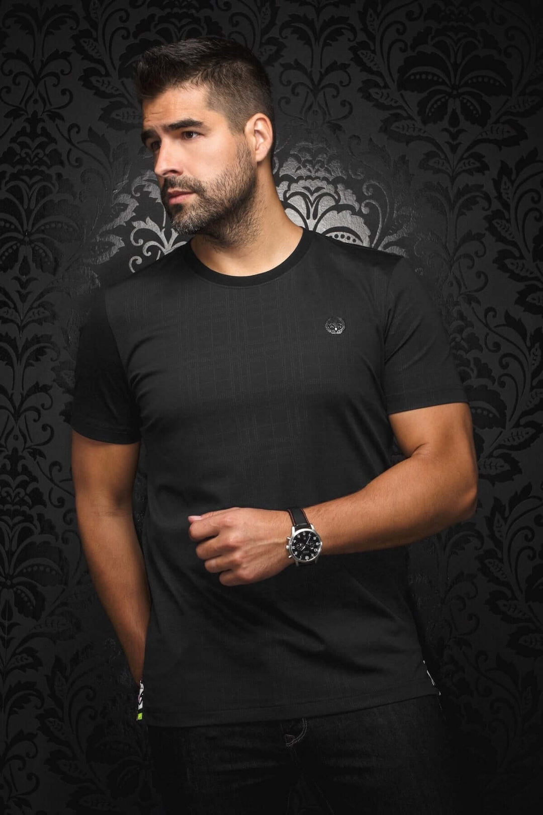 T-shirt moderne Varenna à col rond noir, motif ton sur ton, coupe près du corps, porté par un homme.