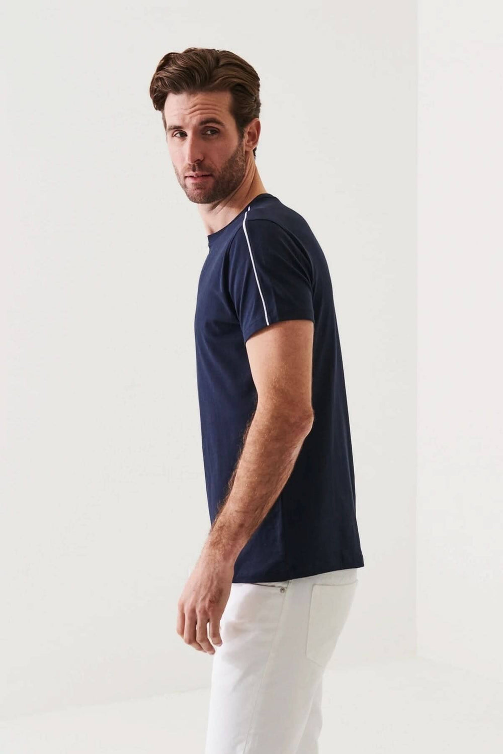 Homme portant un t-shirt à col rond bleu marine avec ligne blanche, coupe régulière, en coton pima.