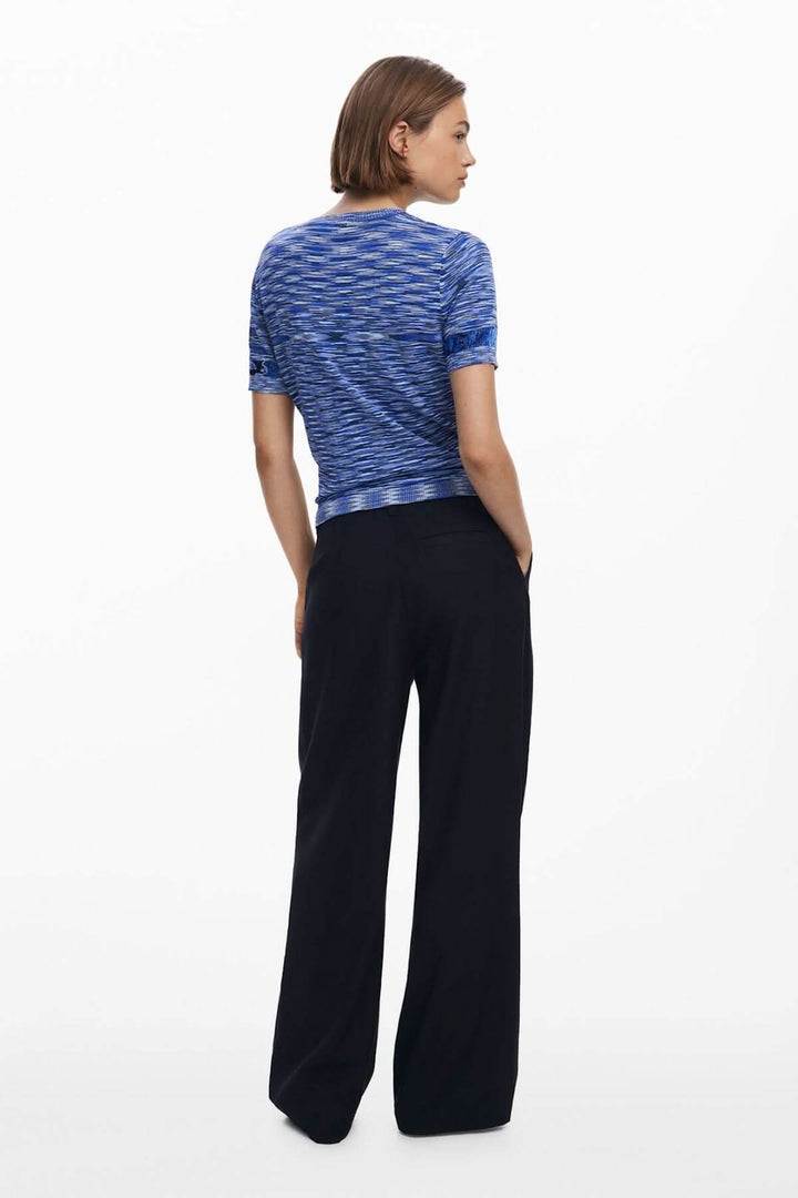 T-shirt en tricot avec motif topographique, manches courtes, coupe ajustée, porté avec pantalon noir, vue arrière sur fond blanc.