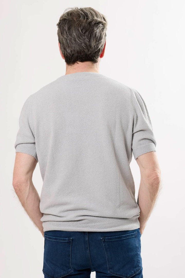 Homme portant un t-shirt gris élégant, vue de dos, avec des manches courtes et un col rond.