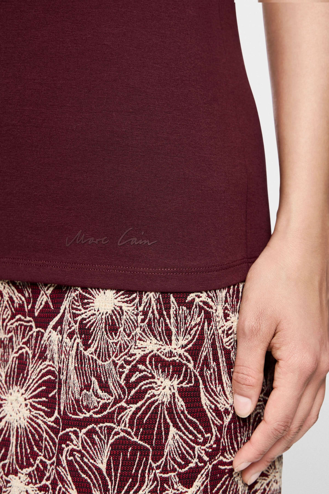 T-shirt manches courtes bordeaux avec jupe à motifs floraux, vue détaillée de la texture et de la bordure.