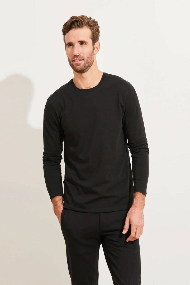 Homme portant un t-shirt noir à manches longues et col rond en coton Pima, idéal pour le confort quotidien.