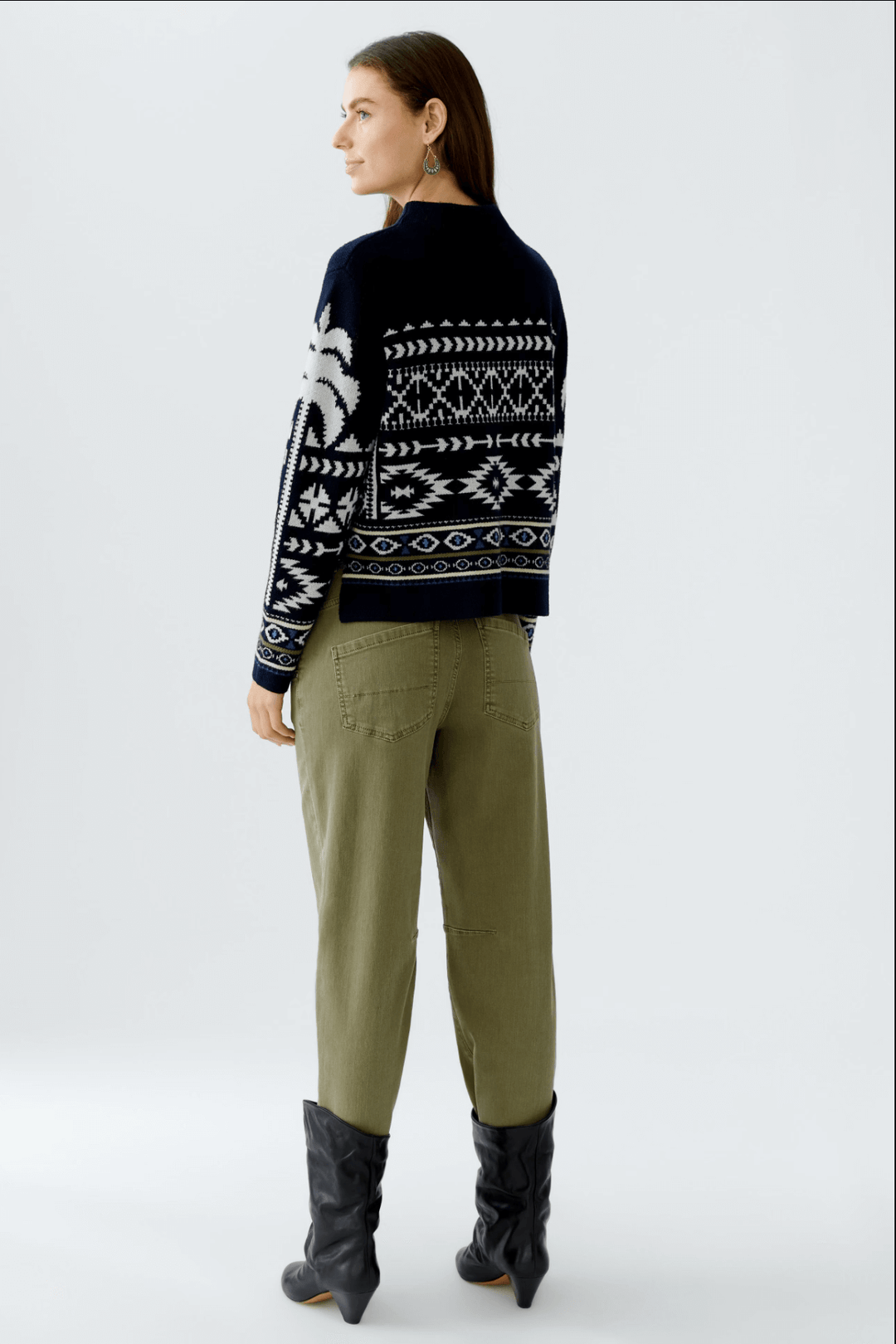 Modèle portant un tricot motif norvégien en jacquard, coupe décontractée, avec col montant et fentes, style cosy et tendance.