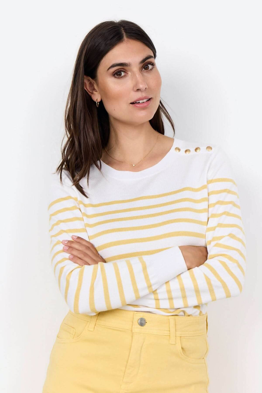 Tricot rayé à encolure ronde avec boutons décoratifs, combines confortablement avec un pantalon ou une jupe.