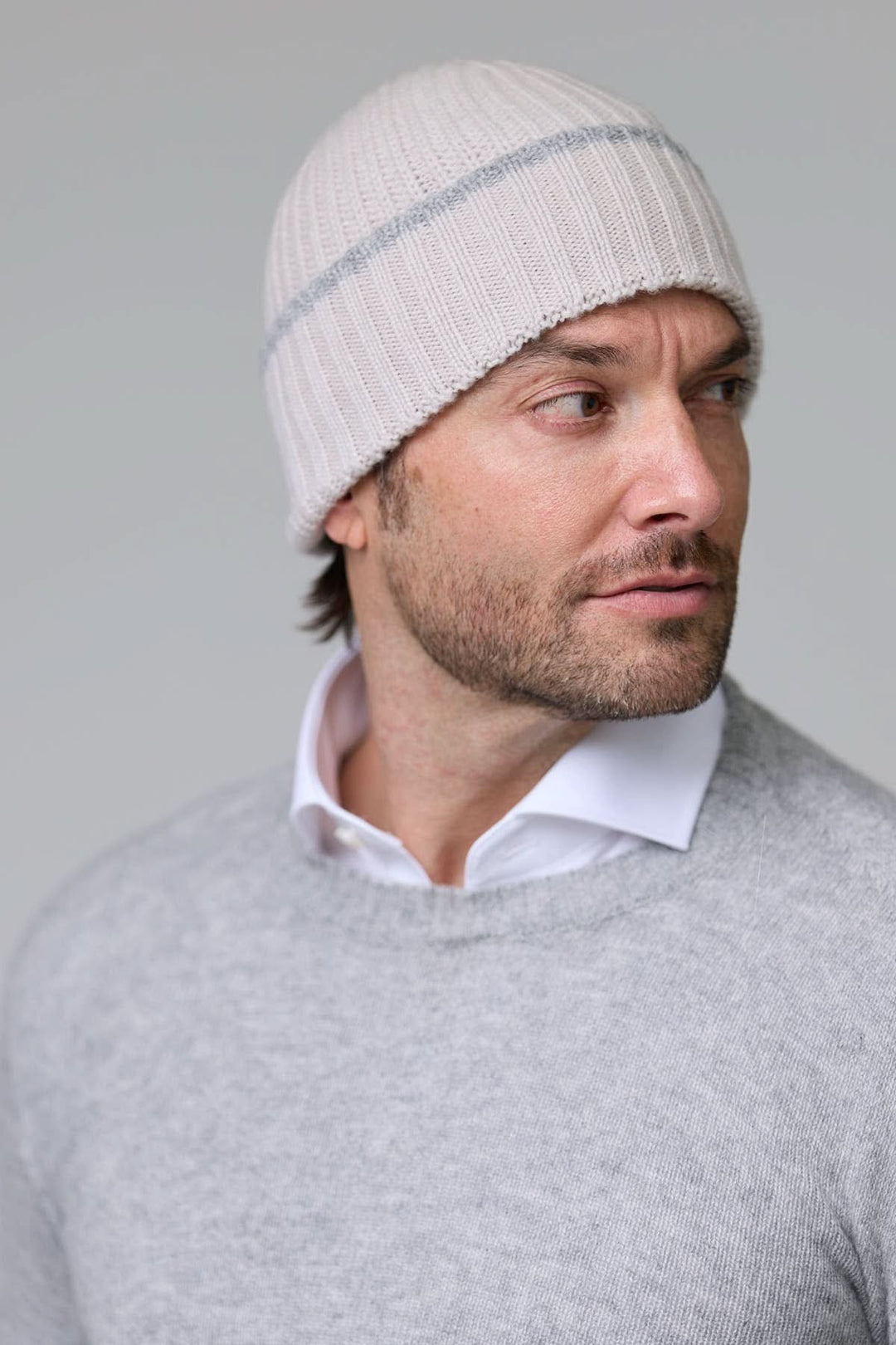 Homme portant une tuque en tricot côtelé blanche avec détail contrastant discret, idéale pour l&