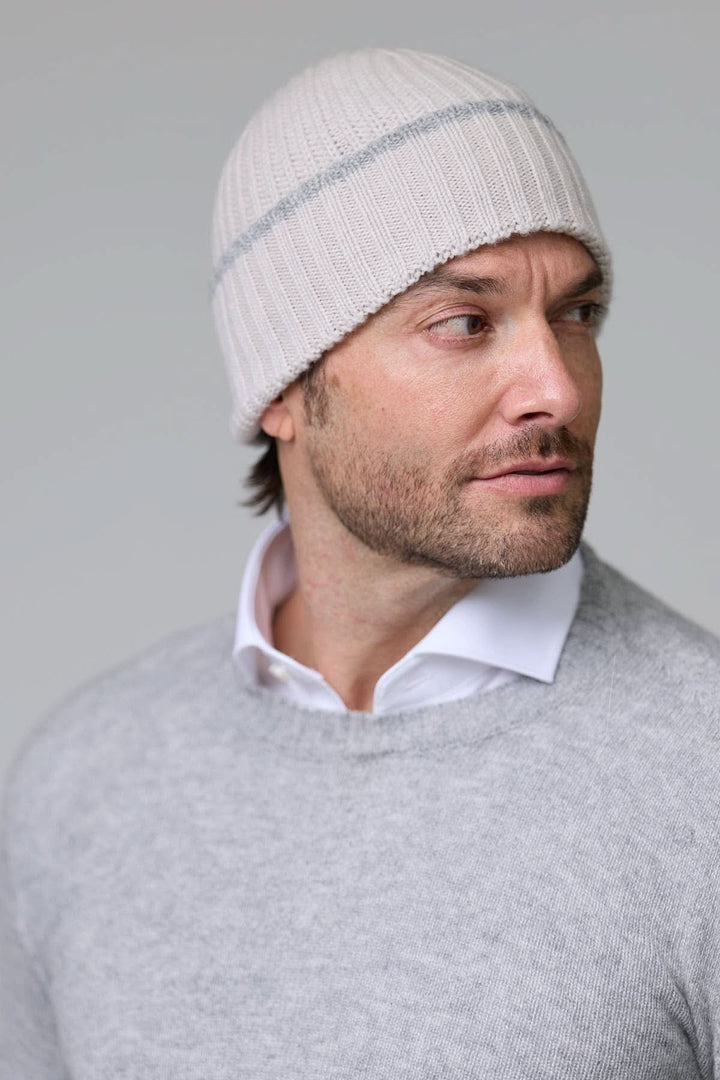 Homme portant une tuque en tricot côtelé blanche avec détail contrastant discret, idéale pour l&