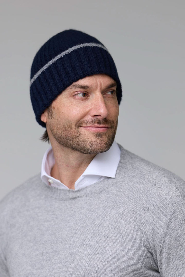 Homme portant une tuque en tricot côtelé bleu avec détail contrastant, parfait pour les journées froides.