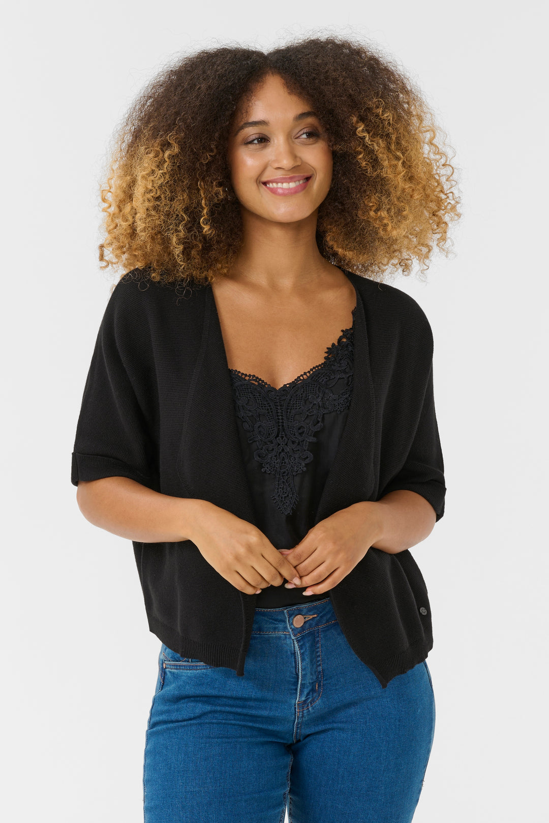 Femme portant une Veste avec manches Sillar noire, coupe fluide et ouverte, idéale pour superposer sur une camisole.