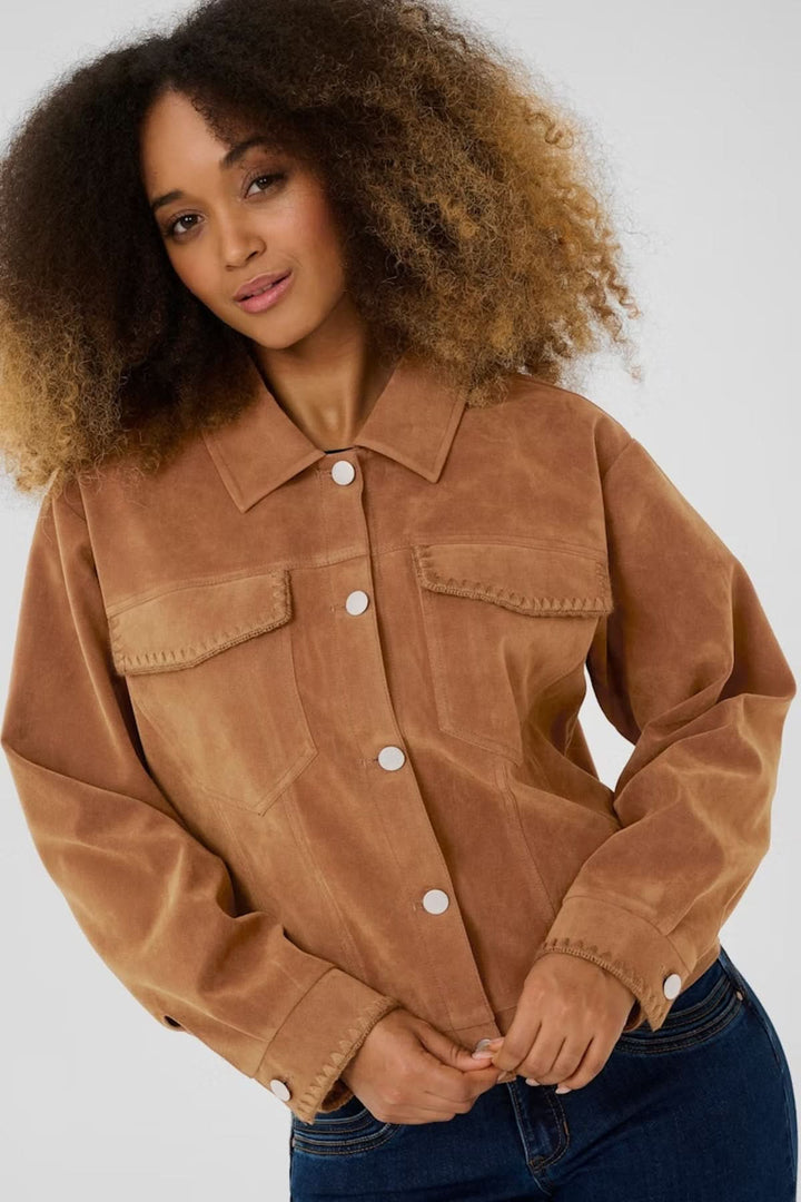 Veste de style western en suédine avec col structuré et boutons-pression, portée par une femme, style casual chic mi-saison.