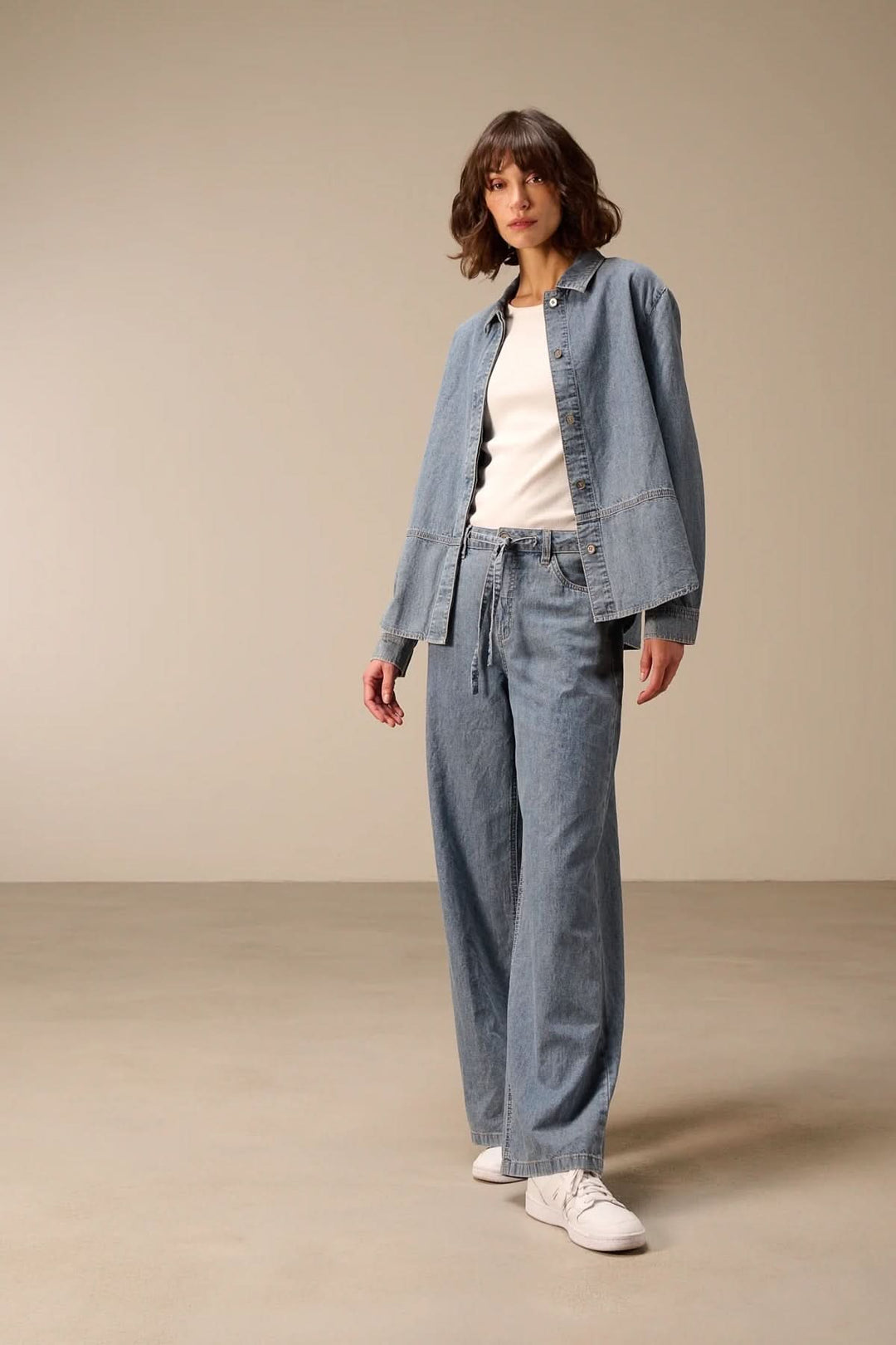 Veste en jean à manches longues portée, style moderne et décontracté, denim souple, idéale pour compléter les tenues quotidiennes.