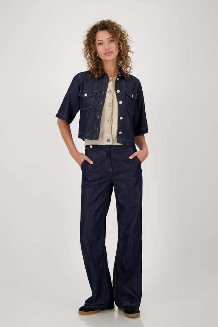 Veste en jeans courte avec manches évasées et fermeture boutonnée, portée avec pantalon pour style casual-chic.