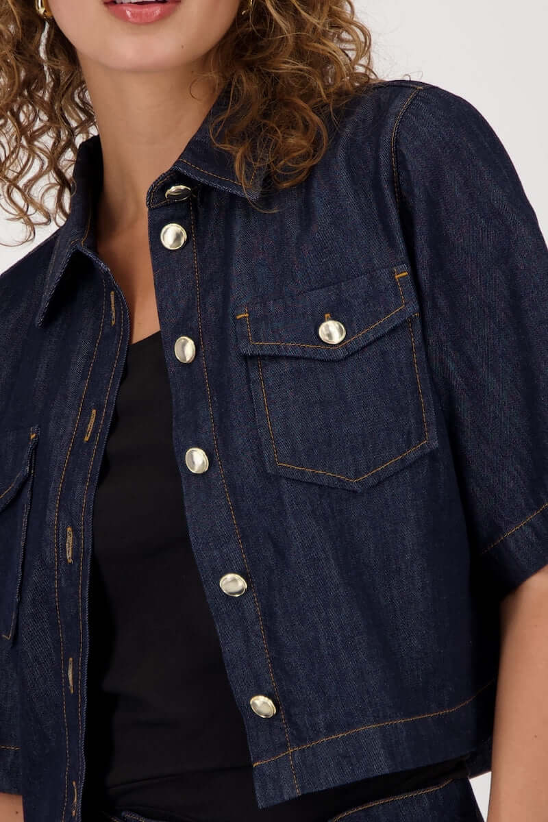 Veste en jeans courte avec manches évasées et fermeture boutonnée, style casual-chic.