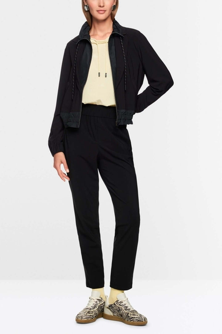Veste légère noire avec éléments sportifs et élégants, col à revers style blazer, poignets élastiques, fermeture éclair.