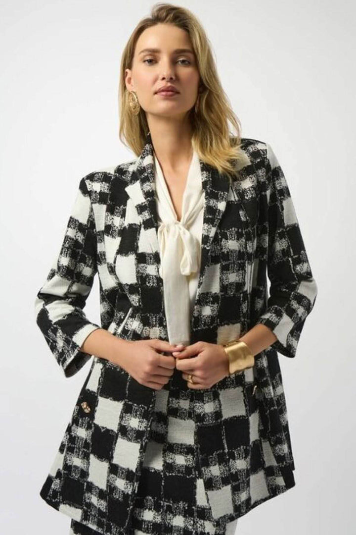 Veste longue à carreaux noir et blanc, coupe droite allongée, col à revers classique, manches 3/4.