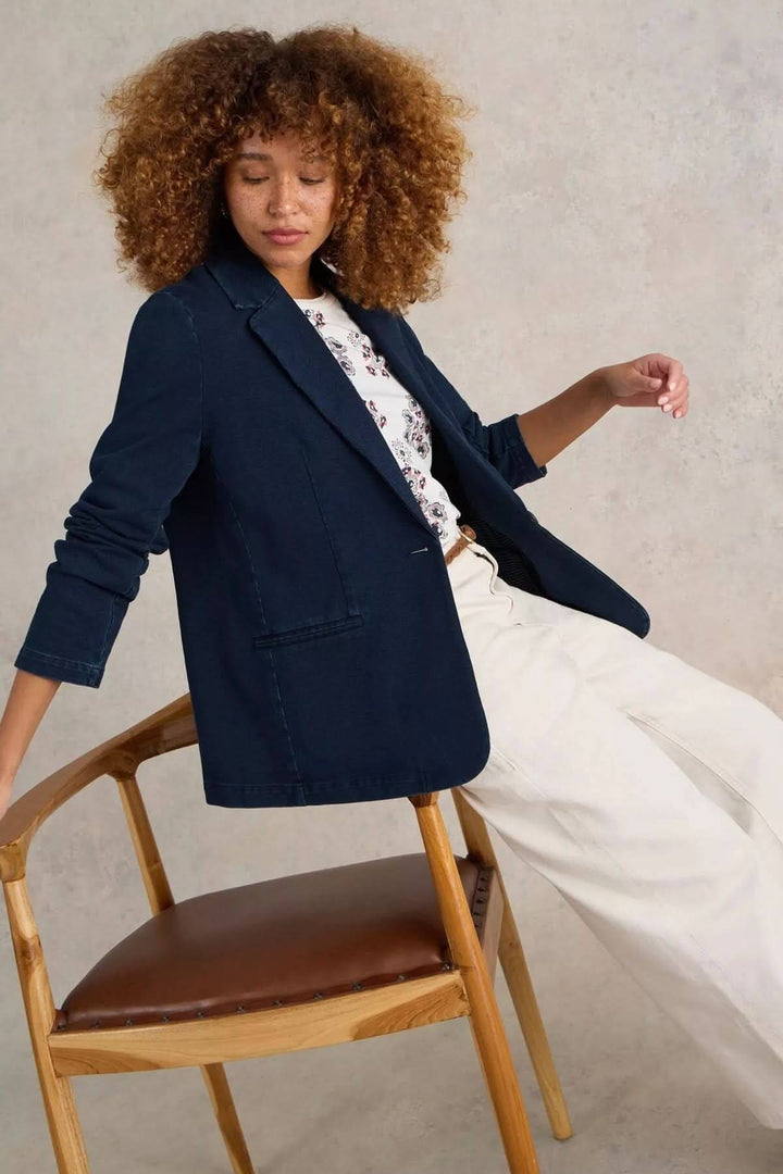 Veston décontracté en denim porté par un modèle, coupe droite et col tailleur, idéal pour un style casual chic avec pantalon et t-shirt imprimé.