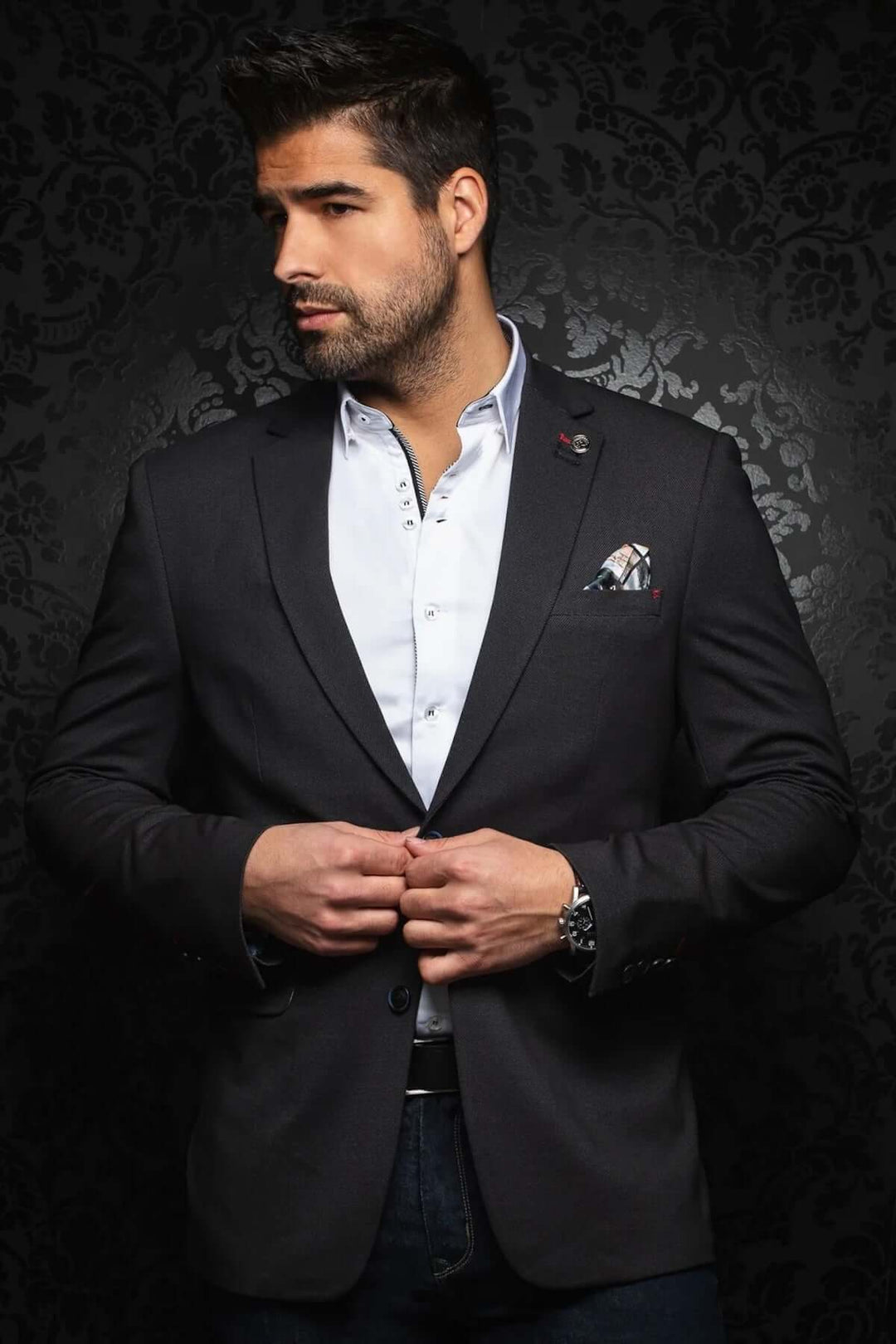 Homme portant un veston moderne et structuré, stylé avec une chemise et une pochette, sur fond élégant.