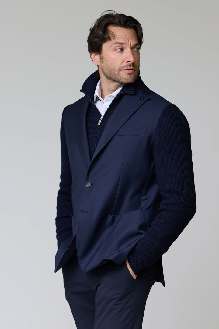 Homme portant un veston hybride tricot et tissu bleu foncé avec col à revers et manches en maille.