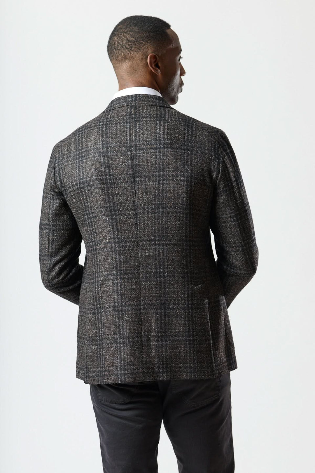 Veston à motif Prince-de-Galles moderne de dos, avec tissu texturé à carreaux, coupe souple, et revers crantés.