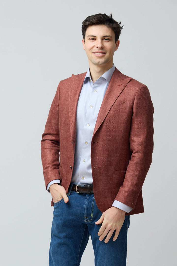 Homme portant un veston texturé en laine, soie et lin avec coupe ajustée et fermeture à deux boutons, sur chemise classique bleue.