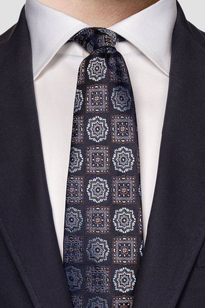 Cravate en soie avec motif médaillon, nuances de bleu, brun et blanc, parfaite pour tenues formelles.