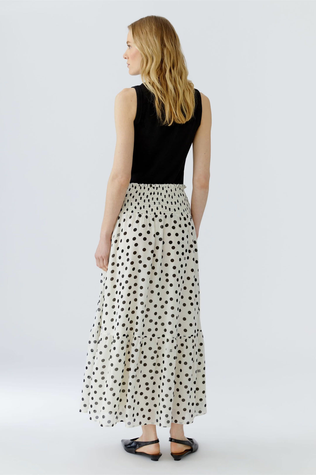 Front view of a long black-polka-dot skirt Oui for women, with a ruffled hem - Valérie Simon