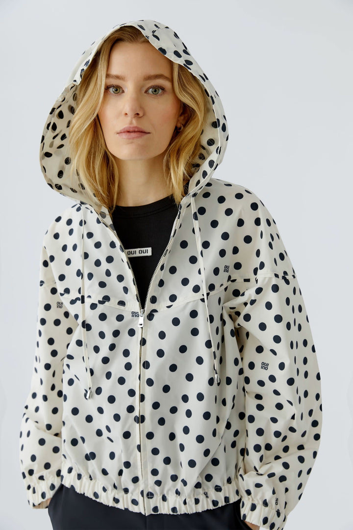 Front view of a black-and-white polka-dot coat worn with a hood Oui for women - Valérie Simon