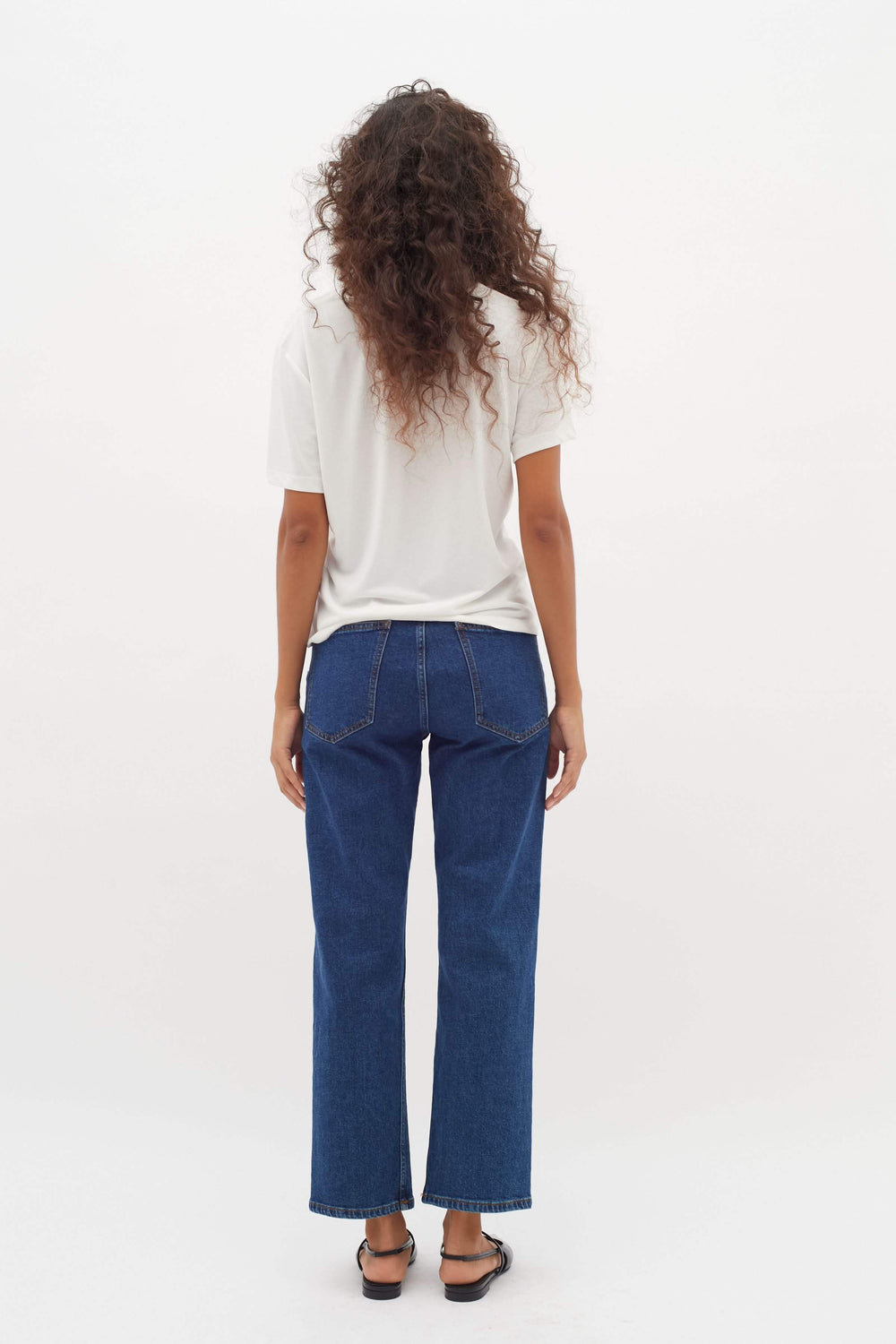 Dos d'une personne portant un T-shirt col en V Liliana blanc avec un jean, mettant en avant le confort et la polyvalence au quotidien.
