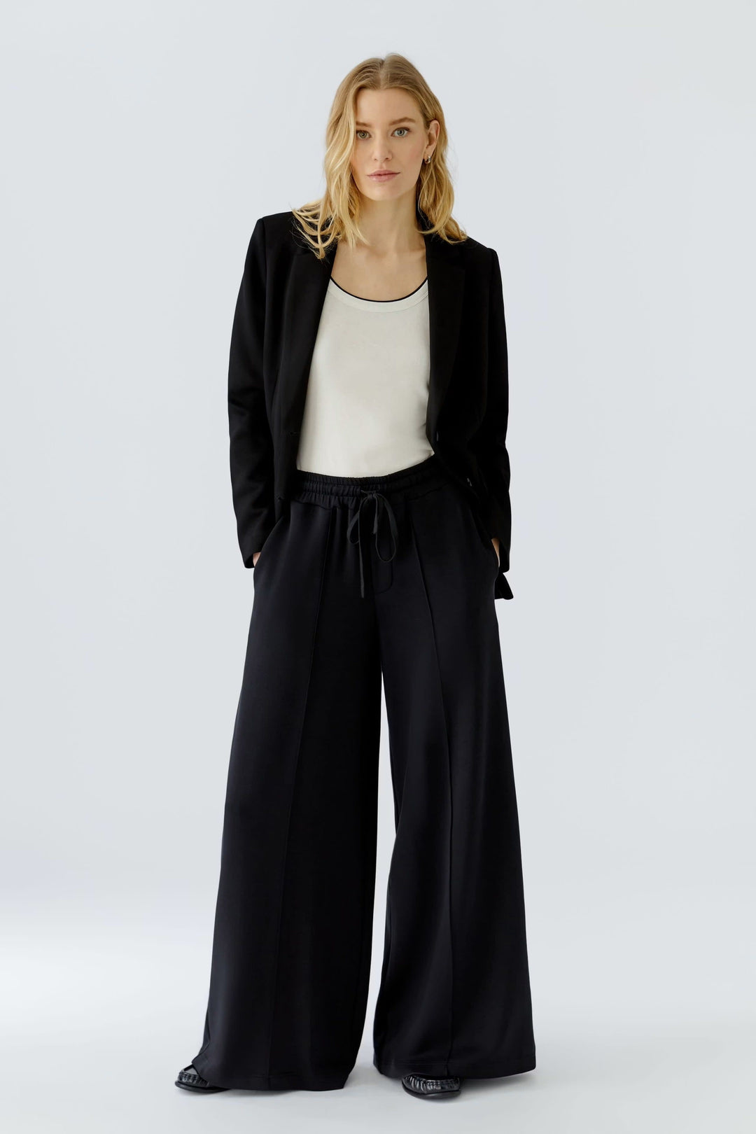 Overview of gray wide-leg pants with an elastic waistband, worn - Valérie Simon Size