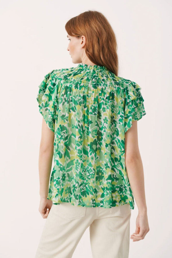 Vue arrière de la blouse fleurie Sinna avec volants et imprimé vert, en 100% viscose.