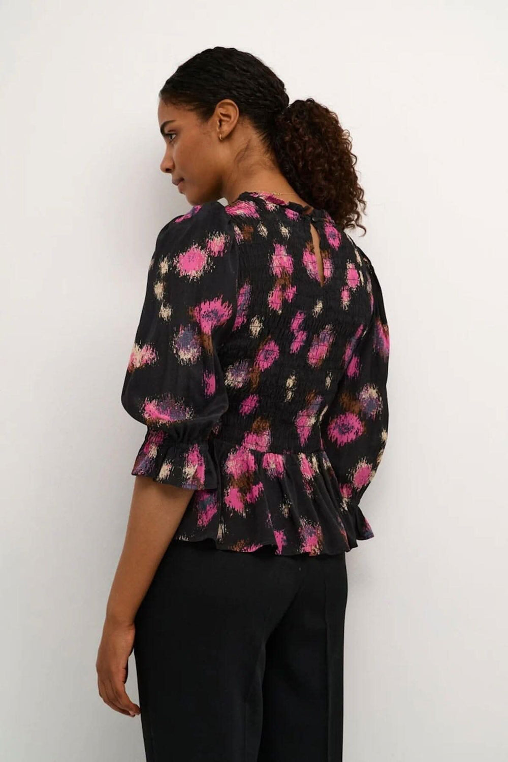 Blouse Lita noire avec imprimé fuchsia, coupe ajustée et manches 1/2 amples, vue arrière.