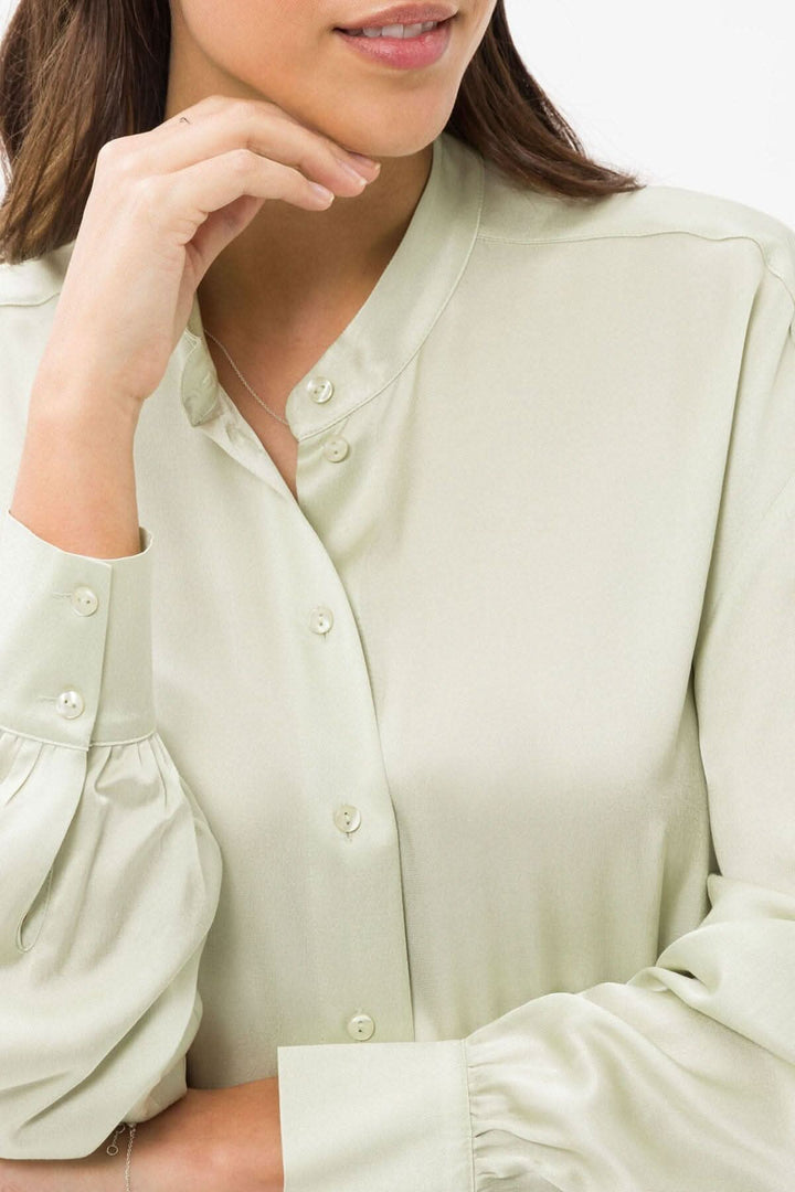 Blouse soyeuse Viv en viscose, col montant, manches bouffantes, tendance et confortable.