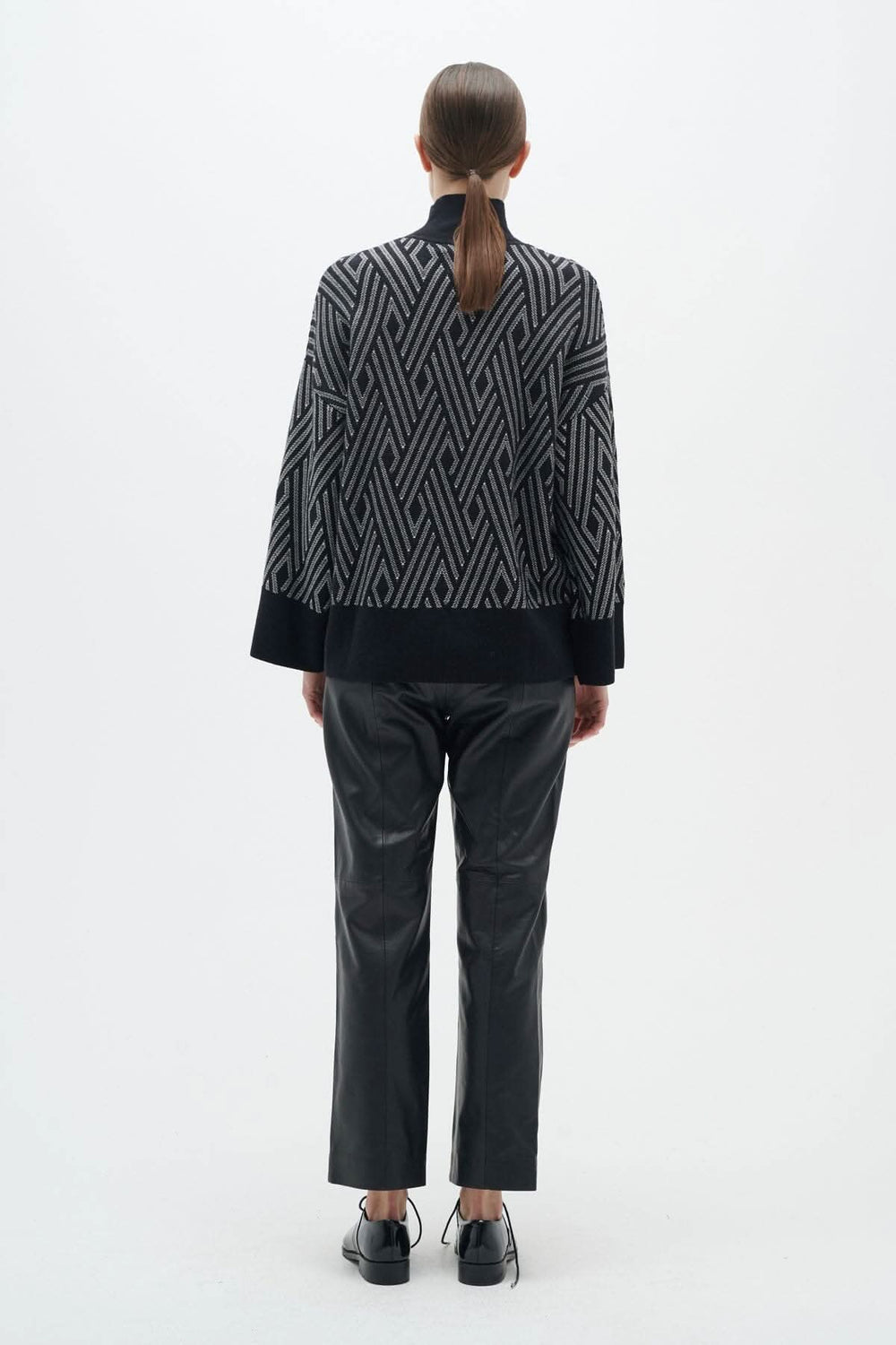 Chandail Gittel ample et ajusté, col montant, motifs géométriques, porté avec pantalon noir, vue arrière.