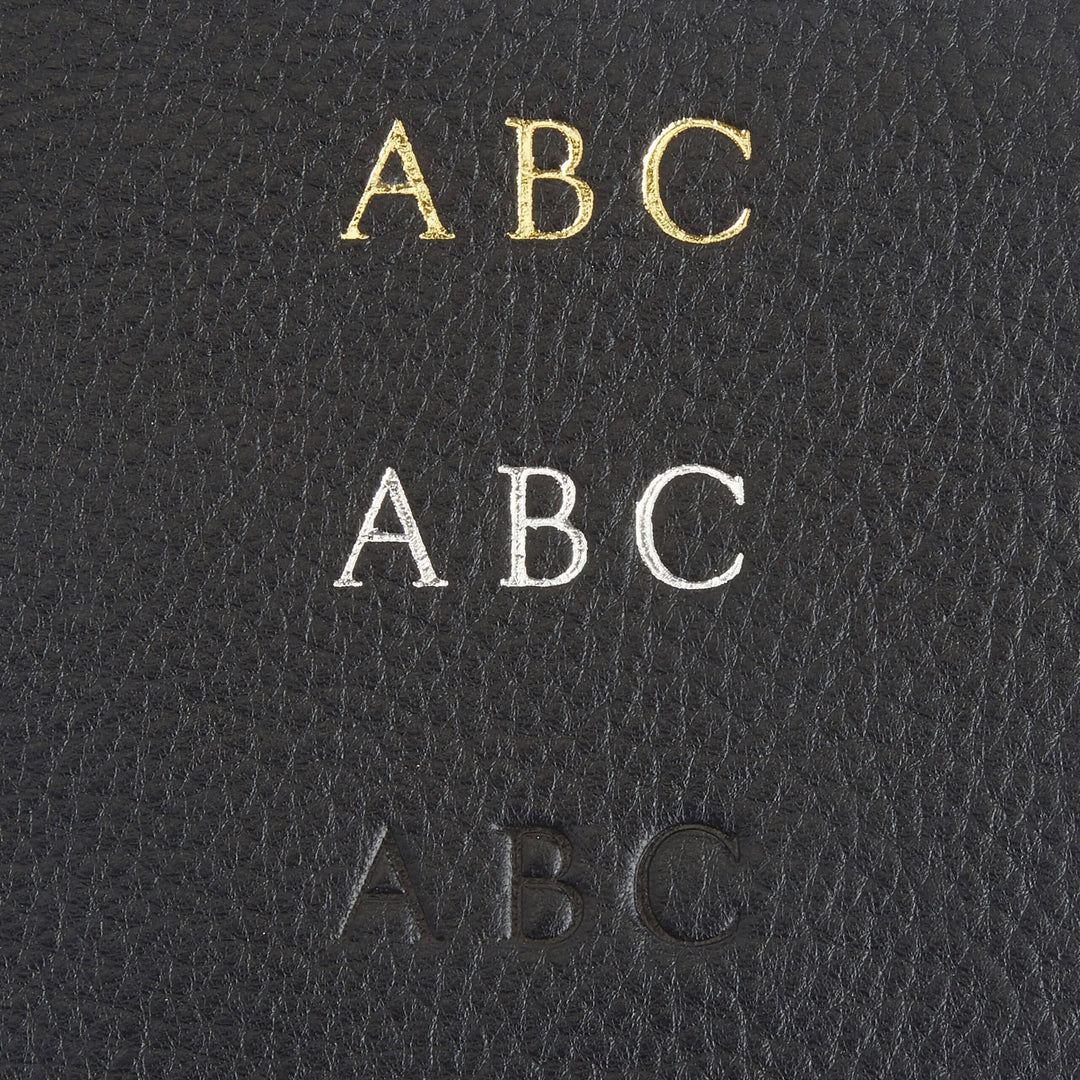 Monogrammed letters ABC in gold, silver, and black on textured leather background.